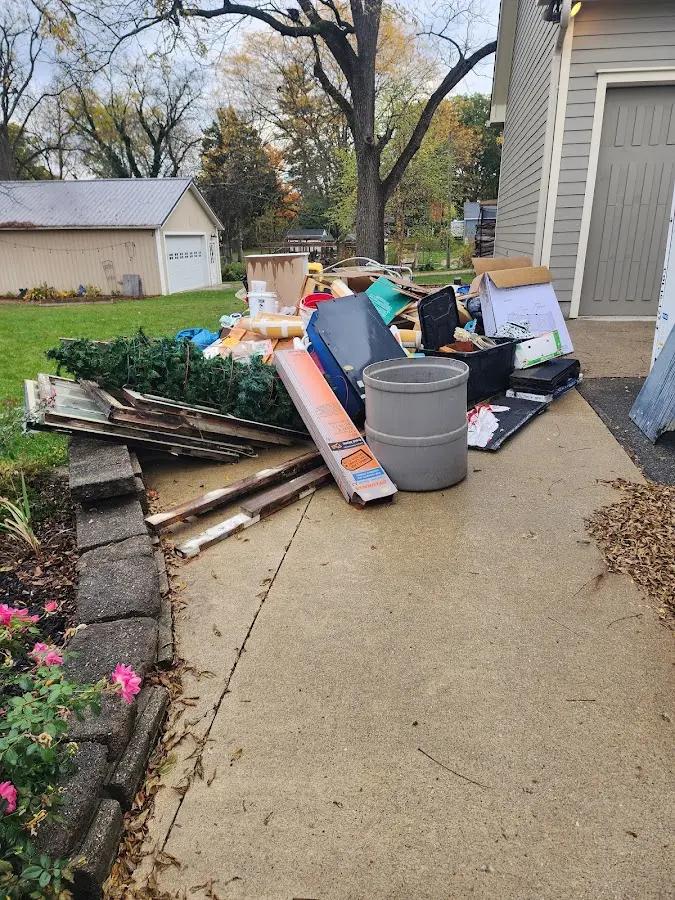 Dumpster being loaded with debris for Estate Cleanout Dumpster Rental in Genoa